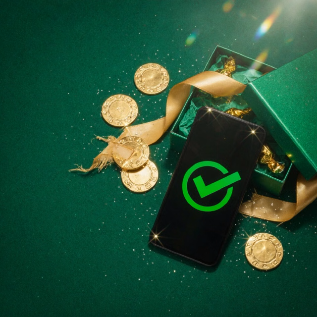 Phone showing a green tick over a completed sign-up form, gift box beside it